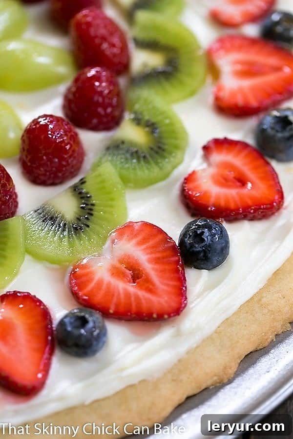 A close-up view of the vibrant and fresh fruit toppings on a Fresh Fruit Pizza, highlighting blueberries, raspberries, and kiwi slices.