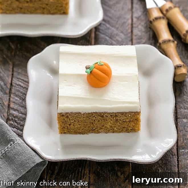 Square pumpkin bars topped generously with a swirl of cream cheese frosting.