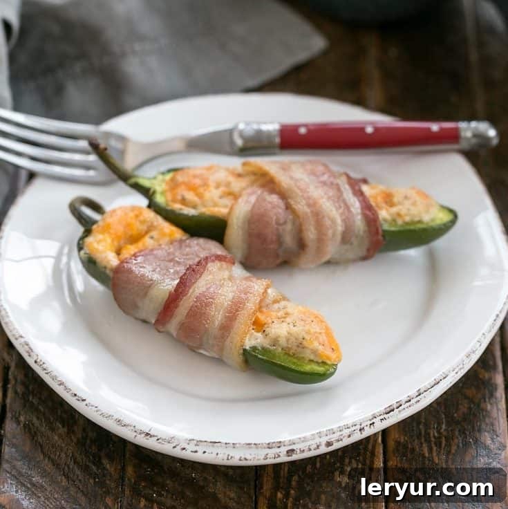 Crispy bacon-wrapped jalapeno poppers, filled with cheese and spices, ready to be served as an appetizer.