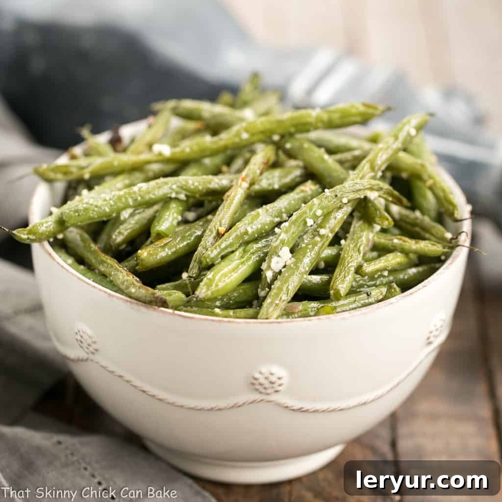 Roasted green beans seasoned with garlic and Parmesan cheese, served as a vibrant side dish.