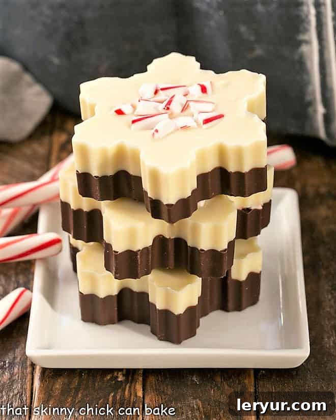 Peppermint Bark Snowflakes elegantly stacked on a pristine white plate, adorned with festive candy cane garnish, embodying the spirit of the holidays.