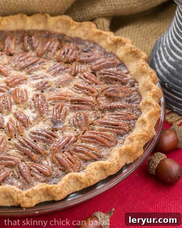 A classic pecan pie, beautifully enhanced with bourbon, nestled in a flaky pastry crust and set against a vibrant red napkin, showcasing its rich texture.