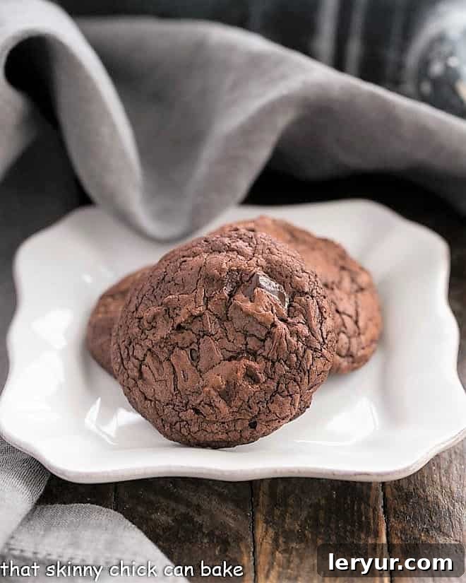Black Gold Cookies - with two types of chocolate, chocolate chunks and minimal flour, these cookies are a chocoholic's dream! Black Gold Cookies on a small white plate