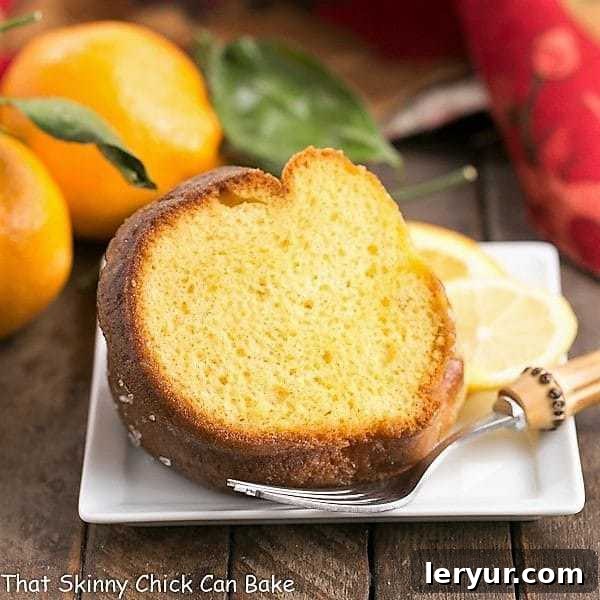 A slice of Easy Lemon Bundt Cake served on a elegant square ceramic dessert plate, showcasing its moist texture and rich glaze.