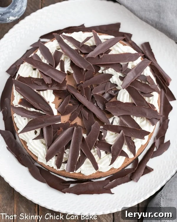 Easy Chocolate Mousse Cake - Chocolate cookie crust, whipped chocolate mousse topped with chocolate shards Overhead view of Easy Chocolate Mousse Cake on a white cake plate.
