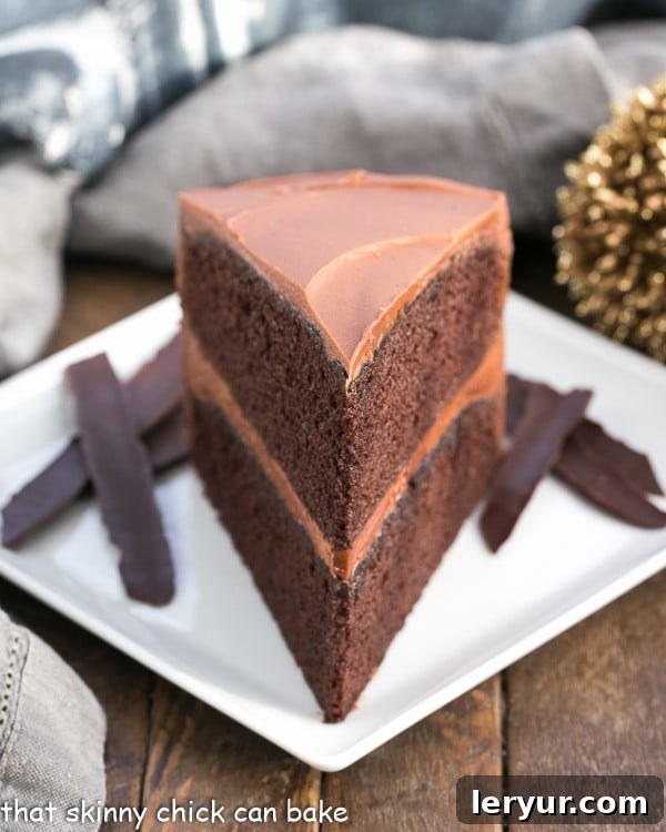 A perfectly sliced piece of moist Chocolate Mayonnaise Cake with rich chocolate frosting on a square white plate, showing its tender crumb.