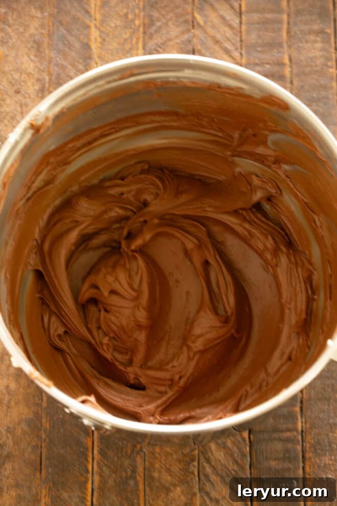 Fully mixed chocolate frosting in a bowl, showing a smooth and rich consistency.