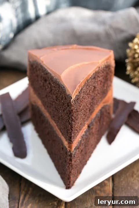 A beautifully frosted slice of chocolate mayonnaise cake on a simple white plate, ready to be enjoyed.