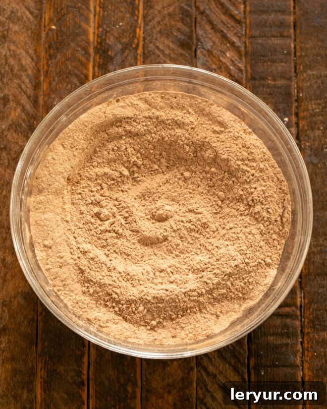 Whisking together dry ingredients (flour, cocoa, baking soda, baking powder) in a bowl for the cake batter.