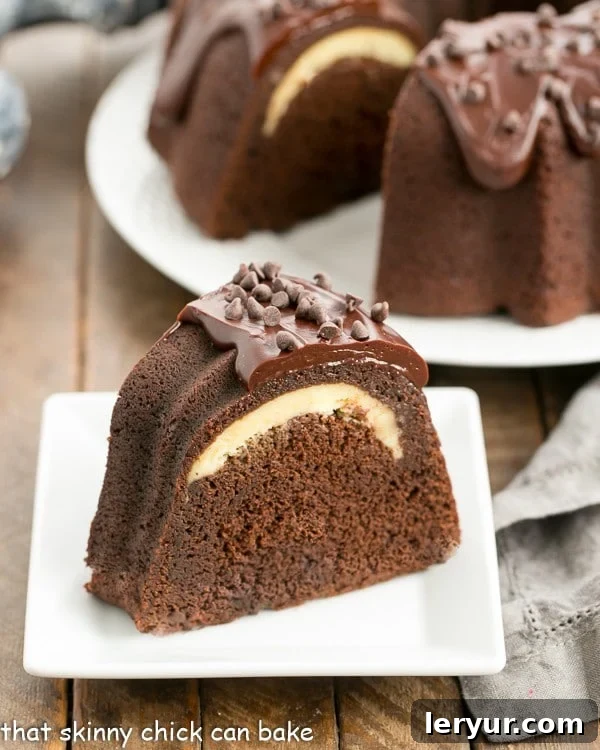 A perfectly cut slice of Cheesecake Stuffed Chocolate Bundt Cake, showcasing the creamy cheesecake layer within.