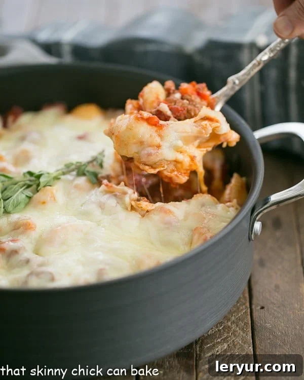 A large pan of freshly baked Cavatini Supreme, with a serving spoon scooping out a generous portion.