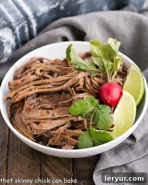 Effortless Slow Cooker Carne Asada 2 Slow Cooker Carne Asada in a white bowl with a radish and lime wedges, showcasing its rich color and tender texture.