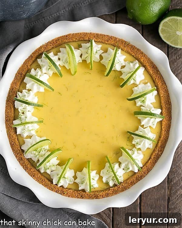 A vibrant Key Lime Pie with a golden graham cracker crust, displayed in an elegant white ceramic pie plate, ready to be served.