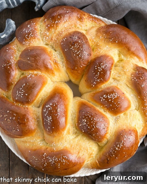 A stunning overhead view of a freshly baked, perfectly golden-brown round loaf of braided Easter bread, showcasing its intricate pattern.