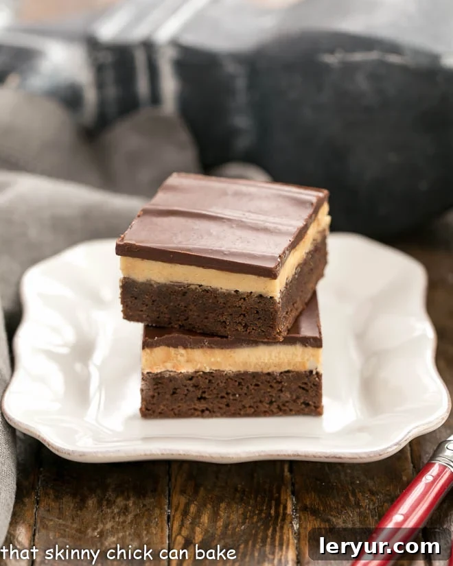 Peanut Butter Truffle Brownies stacked on a square white plate, showing the layers.