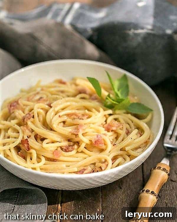 A classic bowl of Spaghetti Carbonara garnished with fresh parsley on a wooden surface.