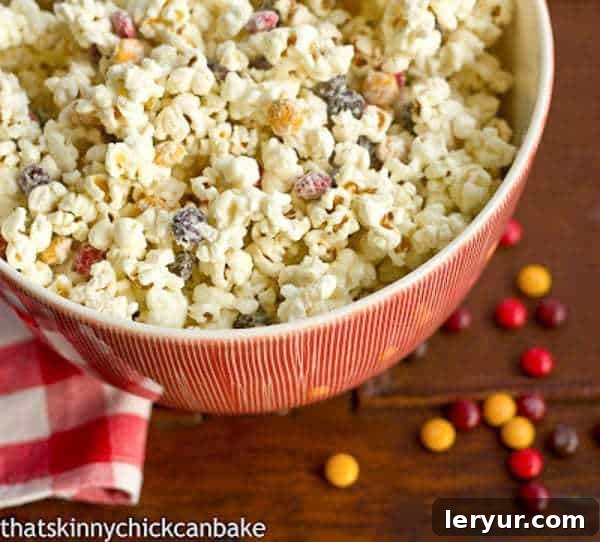 Easy holiday white chocolate popcorn decorated with colorful M&M's.