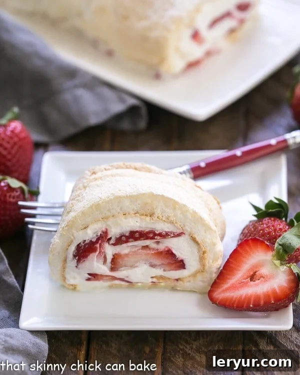 Strawberry Filled Meringue Roulade slice on a white dessert plate