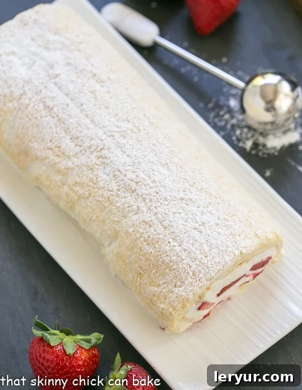 Strawberry Filled Meringue Roulade on a white ceramic serving tray