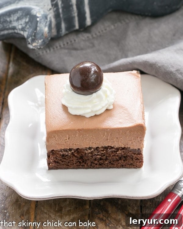 French Silk Pie Brownies - A spectacular 2-in-1 dessert that's a cinch to prepare! Decadent French Silk Pie Brownies arranged neatly on a pristine white ceramic plate, showcasing their inviting layers.