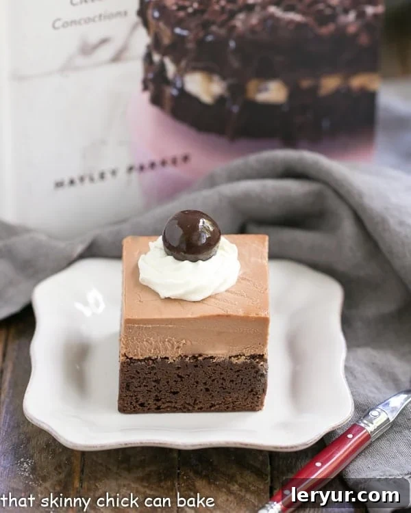 French Silk Pie Brownies - A spectacular 2-in-1 dessert that's a cinch to prepare! A close-up of French Silk Pie Brownies on a white plate, with a red-handled fork poised for a bite, emphasizing the delicious texture.