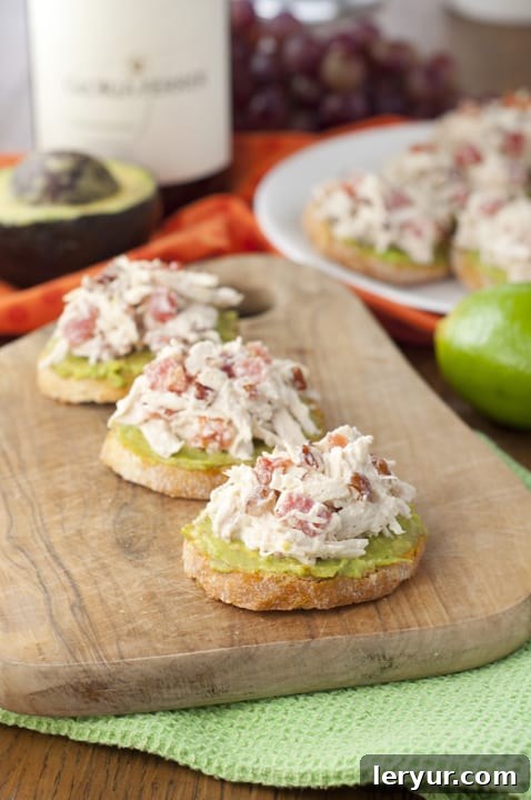 Avocado Chicken Salad Crostini, featuring creamy chicken salad on toasted bread, garnished with fresh herbs.