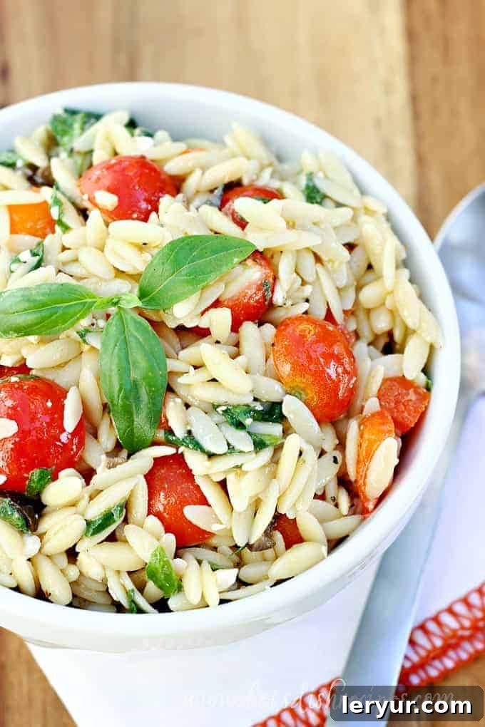 Mediterranean Orzo Salad, a healthy pasta salad with orzo, cherry tomatoes, cucumbers, feta cheese, and olives.
