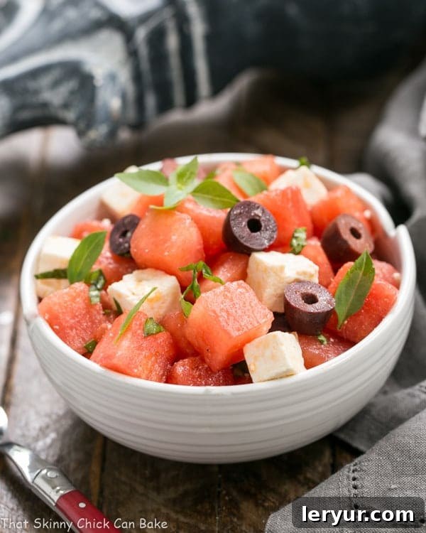 Watermelon Feta Basil Salad with Balsamic Vinaigrette - An unusual, refreshing and irresistible summer side dish! Watermelon Feta Basil Salad with Balsamic Vinaigrette in a white ceramic bowl with a red handled fork.