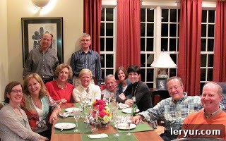Neighbors gathered around a dining table, enjoying a meal together.