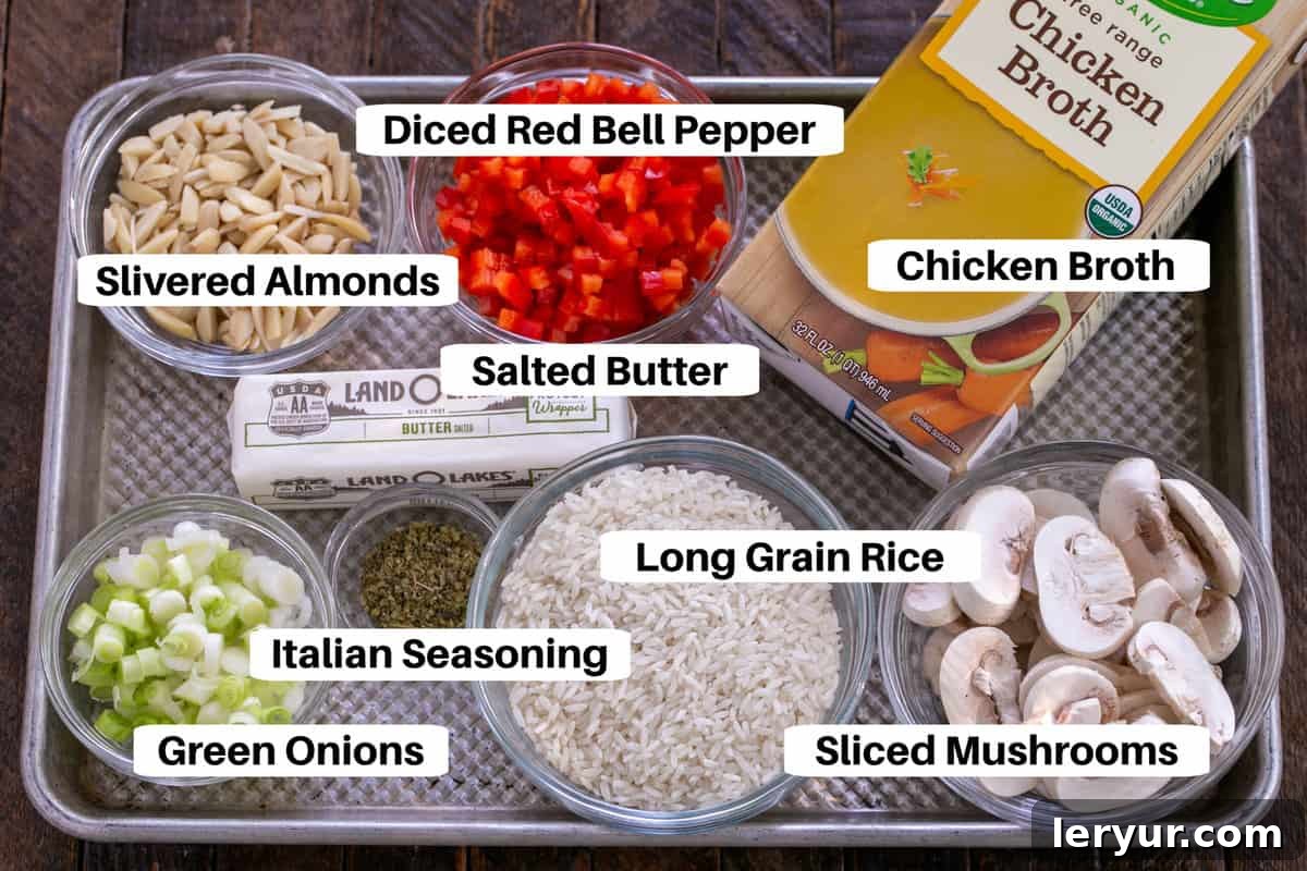 Individual ingredients for Italian Rice Pilaf, including rice, mushrooms, bell pepper, broth, and almonds, neatly arranged on a sheet pan with labels.