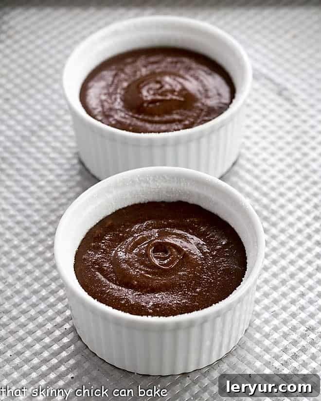 Close-up shot of chocolate lava cake batter perfectly portioned into prepared ramekins, ready for baking.