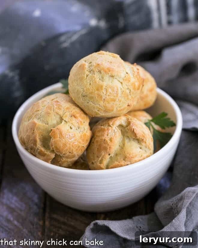 Blue Cheese Gougères - a twist on the classic pâte à choux pastry based cheese puffs with blue cheese and a pinch of cayenne! Absolutely irresistible! #gougeres #cheesepuffs #bluecheese #appetizer #frenchrecipe #frenchappetizer Blue Cheese Gougères in a small white bowl, ready to be served as an elegant French appetizer.