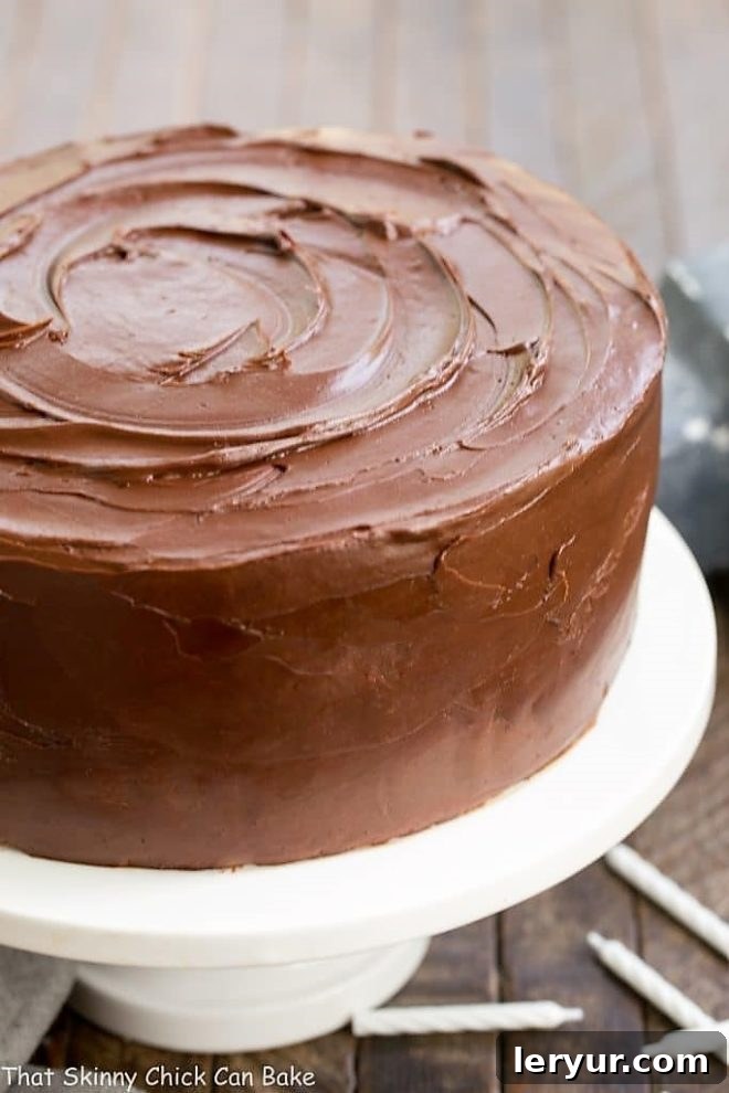 The Best Yellow Cake Recipe - a perfect cake for any celebration! With a moist, fine crumb and incredible chocolate frosting, this layer cake is suitable for a birthday party, baby shower, dinner party, and much more, making it a true showstopper! Classic Yellow Butter Cake with rich Chocolate Icing, elegantly presented on a cake platter, ready to be served and enjoyed by all.