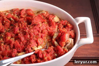 Chicken Feta Casserole - an easy, flavorful weeknight entree Chicken Feta Casserole presented in a white casserole dish with a serving spoon, inviting viewers to enjoy.