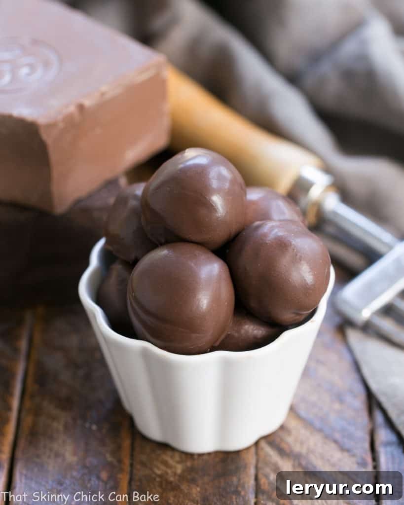 Chocolate Frangelico Truffles - Exquisite truffles flavored with hazelnut liqueur plus a guide for tempering chocolate Rich Chocolate Frangelico Truffles in a small white candy bowl, perfectly spherical and dusted with cocoa.