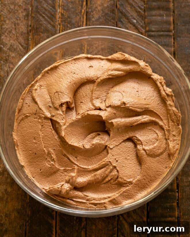 Close-up of fluffy chocolate mousse being prepared in a mixing bowl, prior to filling the cake.