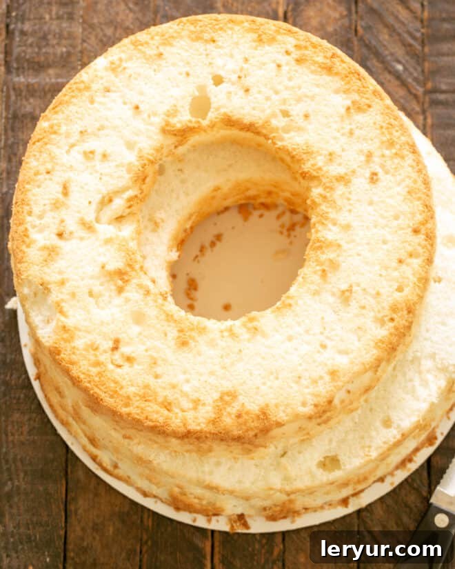 An angel food cake with the top carefully sliced off, ready for filling.