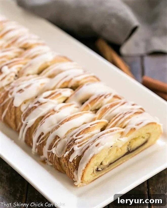 Braided Cinnamon Danish with Laminated Dough - An exquisite breakfast treat Braided Cinnamon Danish with Laminated Dough on a white tray, showcasing its beautiful golden-brown crust and glistening glaze.