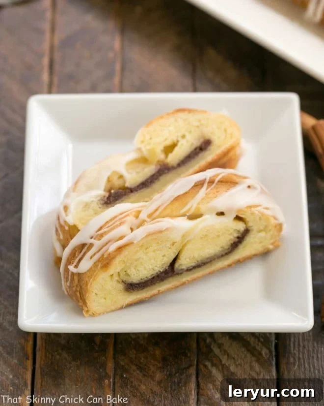 Homemade Flaky Cinnamon Danish Braids 2 Braided Cinnamon Danish with Laminated Dough | An exquisite breakfast treat, perfectly sliced to reveal its intricate layers and cinnamon swirl.