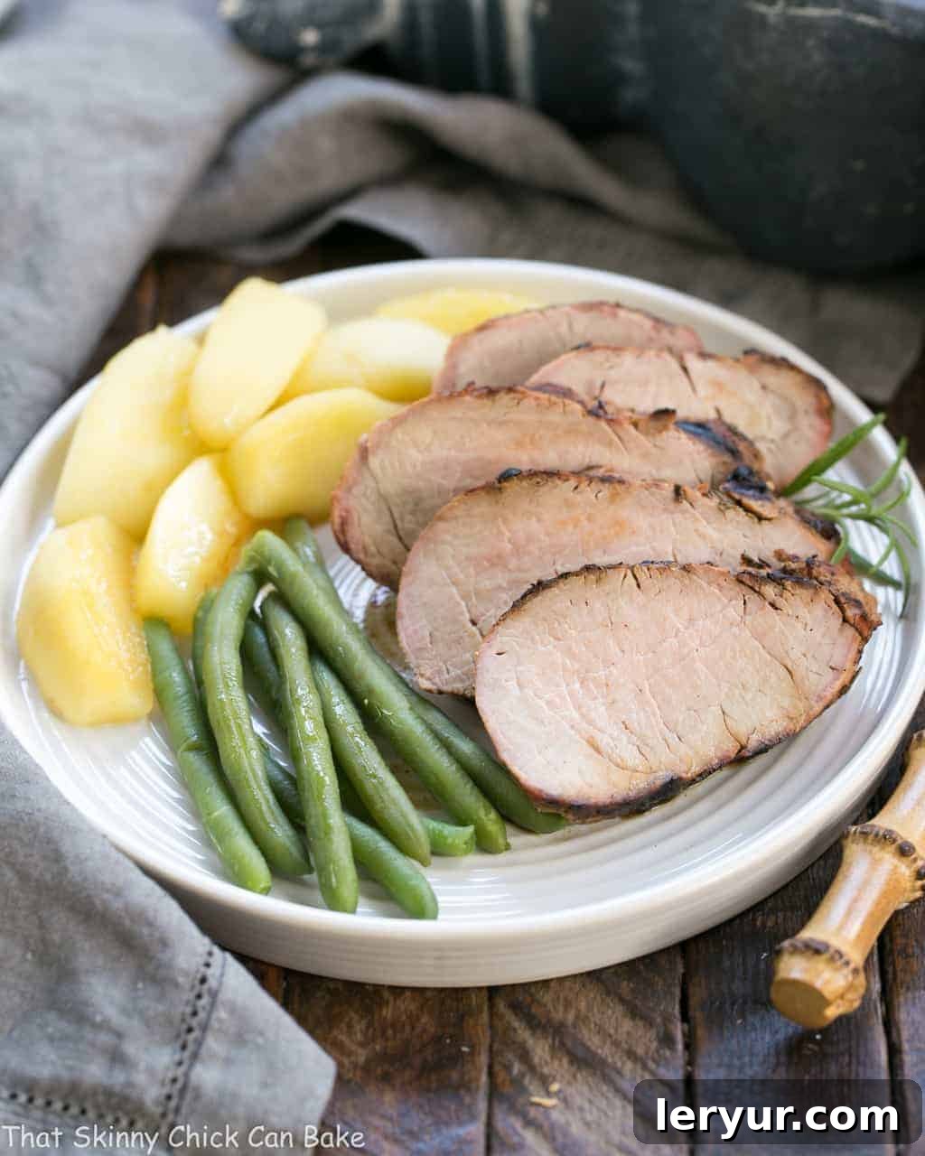 Grilled Maple-Glazed Pork Tenderloin 7 Juicy slices of Maple Grilled Pork Tenderloin, rested and ready to serve, artfully arranged on a platter with the accompanying tender, caramelized apples.