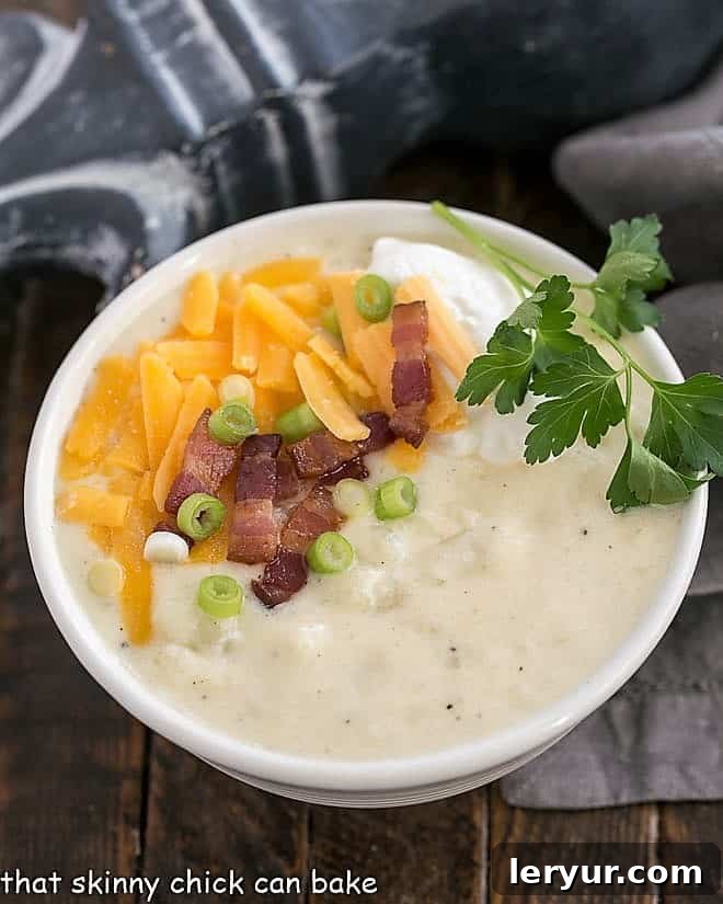 A steaming bowl of Loaded Baked Potato Soup, generously garnished with melted cheddar cheese and crispy bacon bits, ready to be enjoyed.