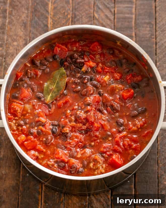 Adding the rest of the ingredients to the pot for simmering.