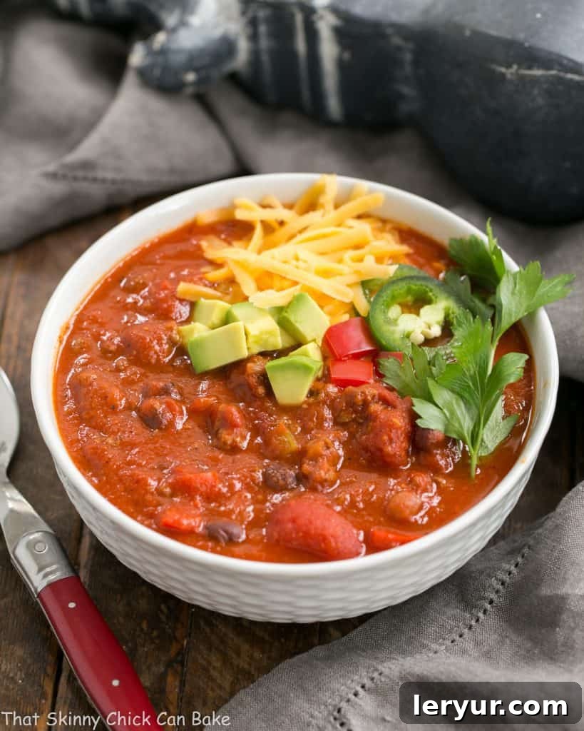 Serving bowls of Easy Black Bean Chili garnished with cheese and avocados.