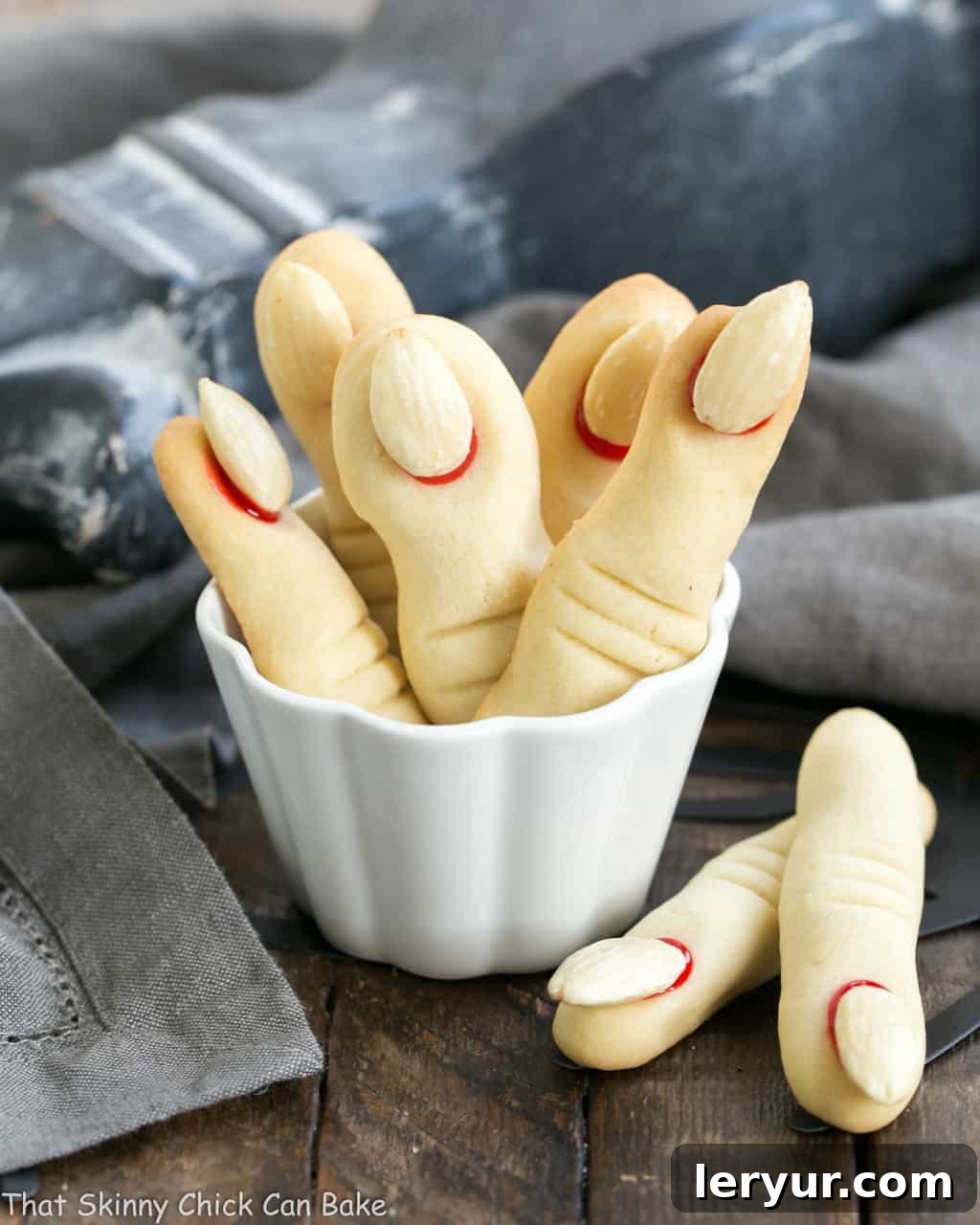 Witches Fingers Cookies standing upright in a white ramekin, ready for a Halloween party.