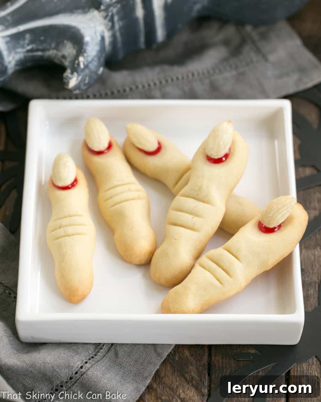 Witches Fingers Cookies fanned out on a rimmed white square plate, showcasing their creepy details.