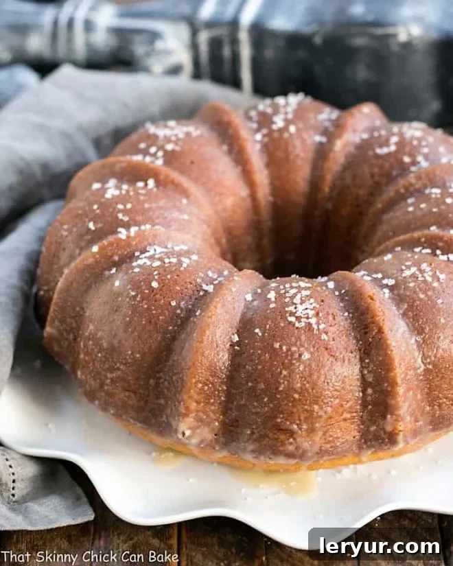 Kentucky Butter Bundt Cake - A simple, versatile butter cake that can be served in so many ways! A stunning Kentucky Butter Bundt Cake presented on a beautiful wavy-edged white cake plate, highlighting its golden crust and elegant form.