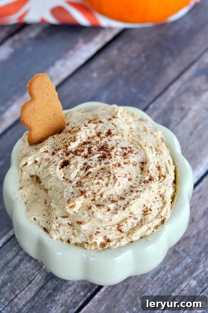 Four-Ingredient Pumpkin Pie Dip served in a bowl with various dippers like cookies and apple slices.