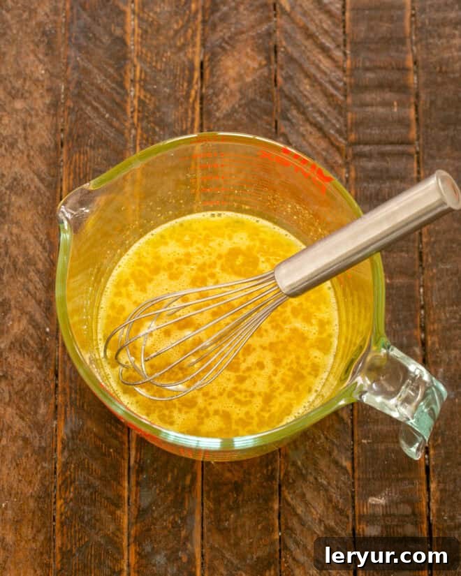 Yaban Mersinli Akçaağaç Şuruplu Ayranlı Pankekler 4 Whisking eggs, salt, and sugar in a bowl.