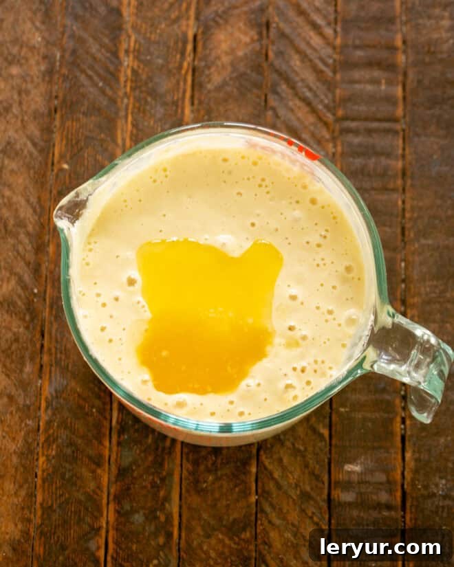 Yaban Mersinli Akçaağaç Şuruplu Ayranlı Pankekler 7 Stirring melted butter into pancake batter.