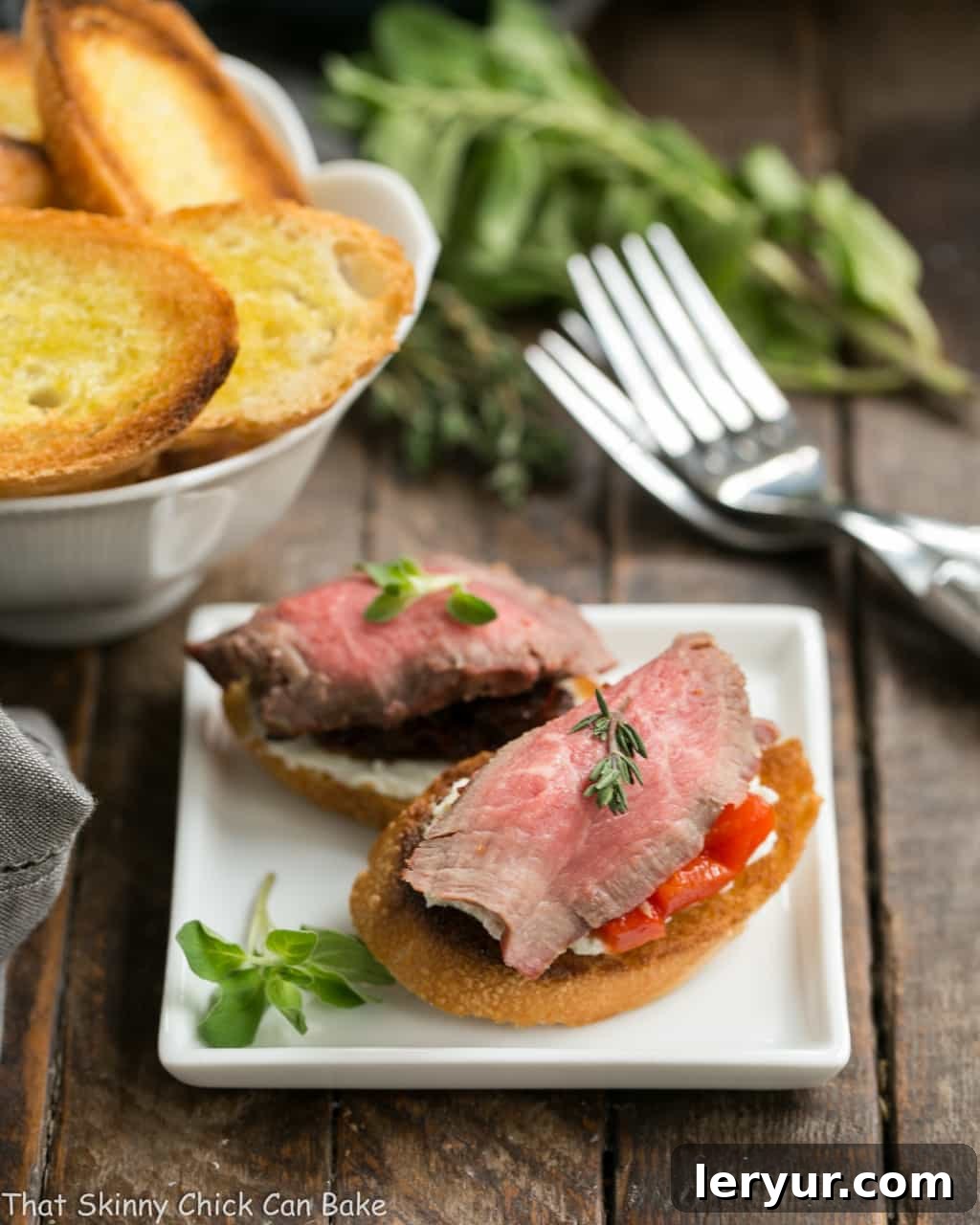 Beef Crostini with Blue Cheese on a square white appetizer plate.